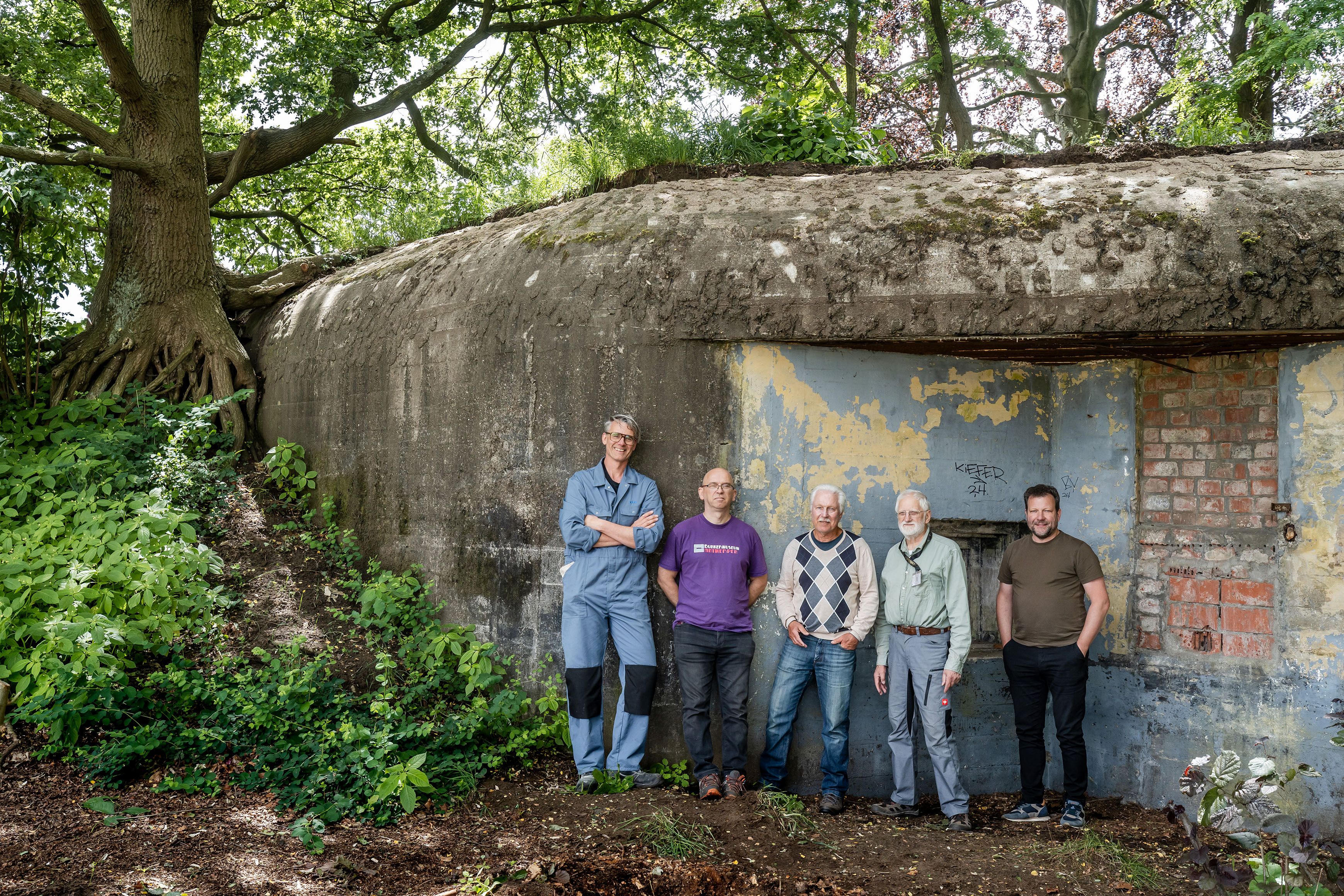 5 vrijwilligers poseren voor de bunker