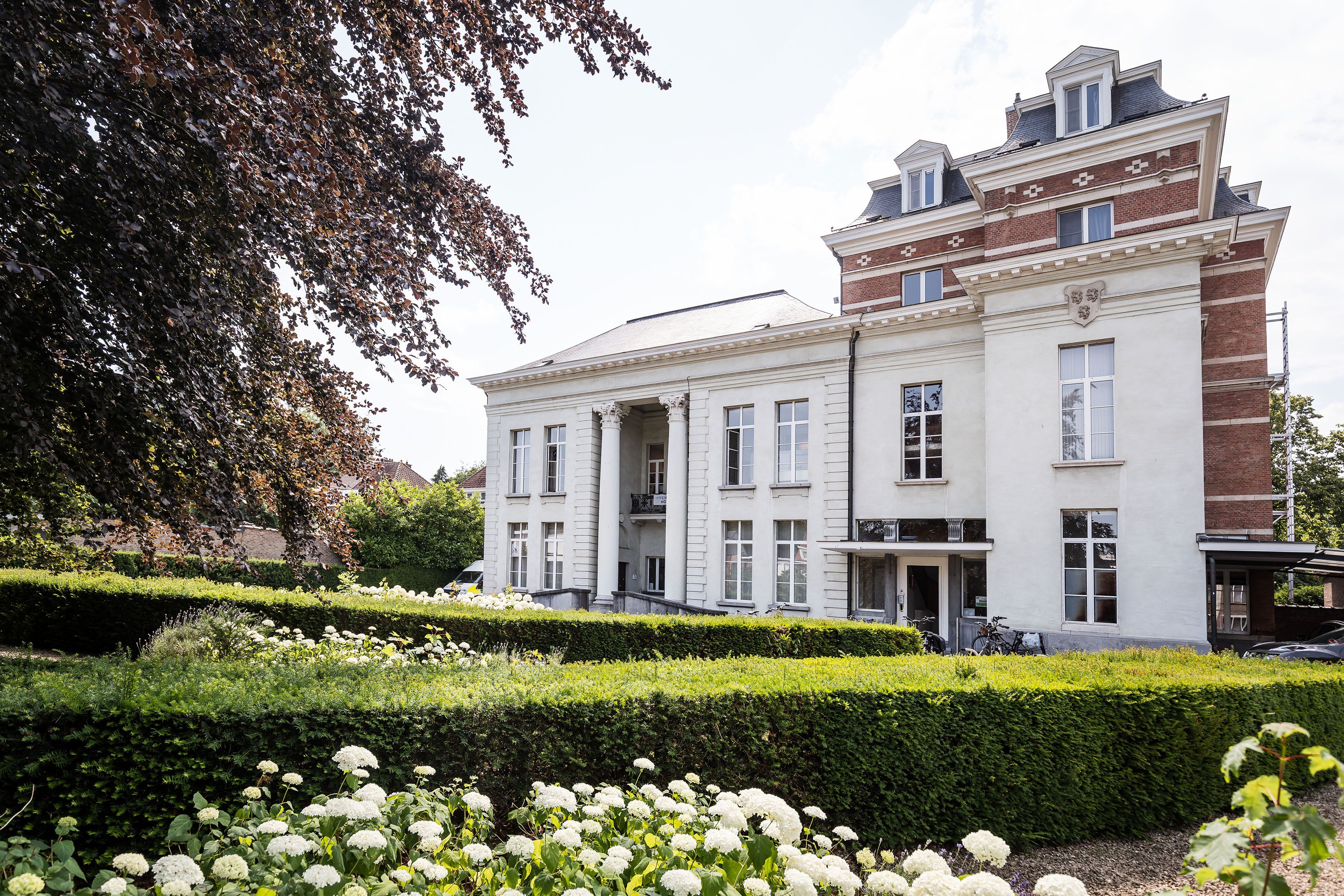 Achtergevel van kasteel Broydenborg met een tuin met een lage groene haag.