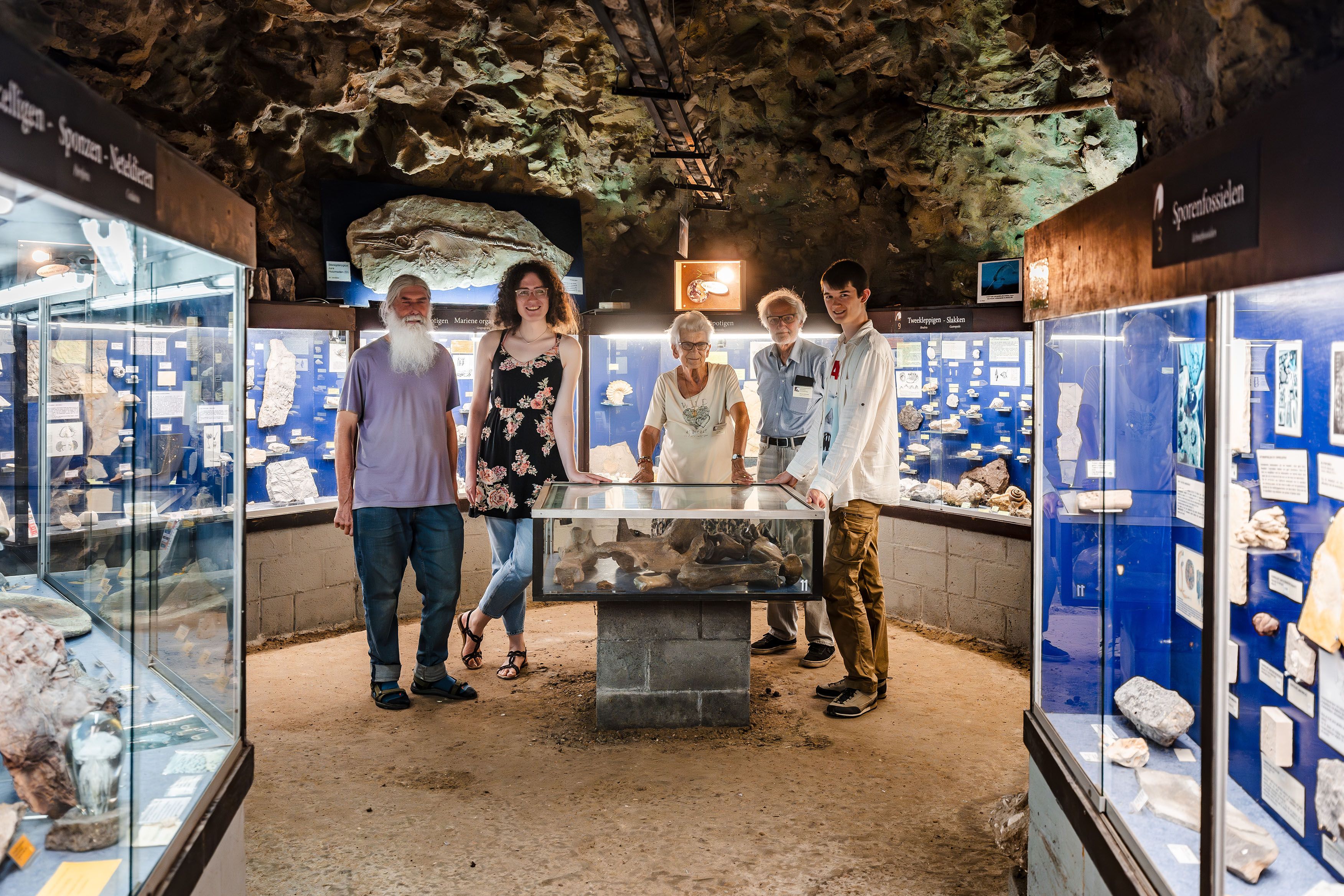 De vrijwilligers poseren in het museum in de grot.
