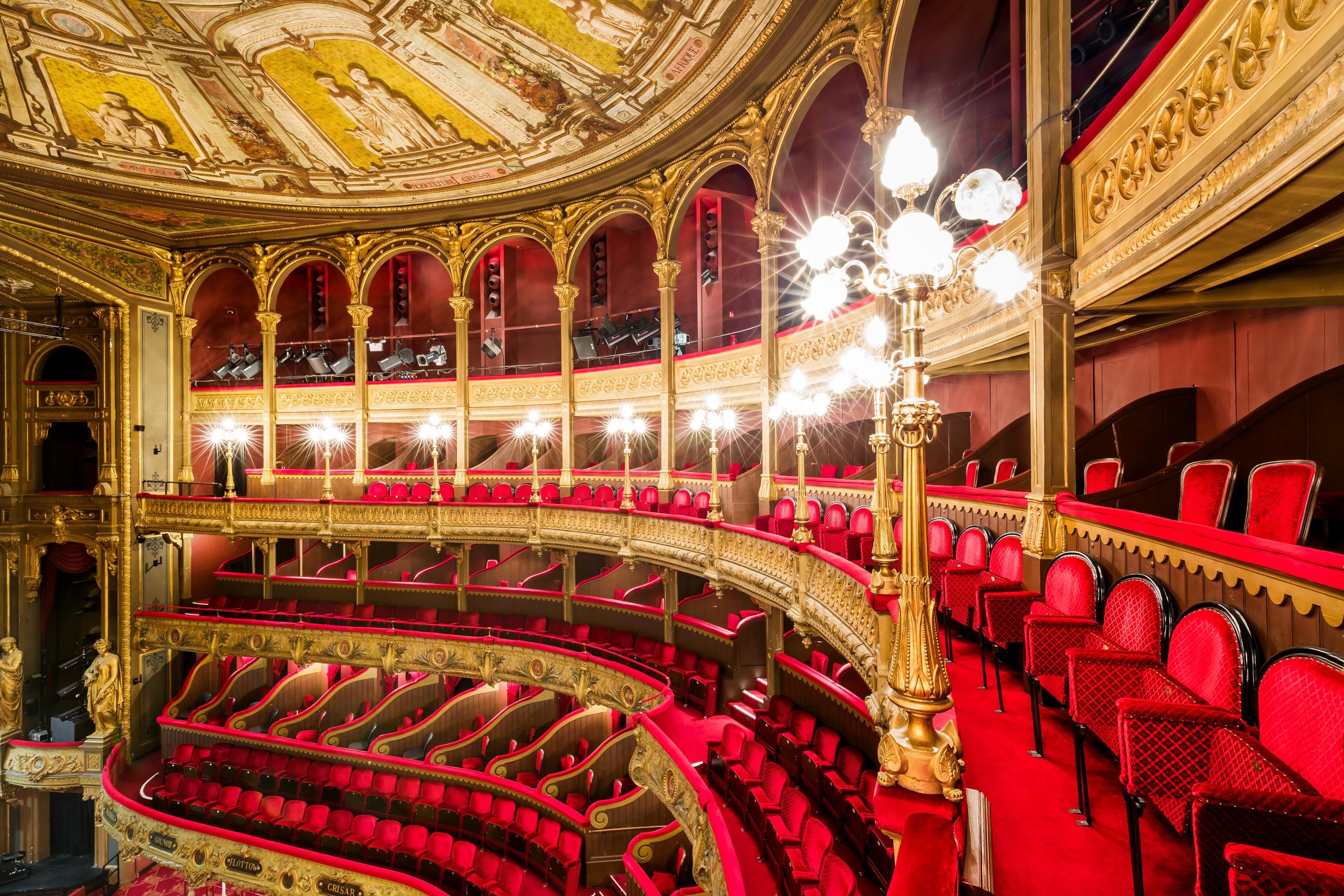Interieur van de theaterzaal met rode fluwelen stoelen en gouden details