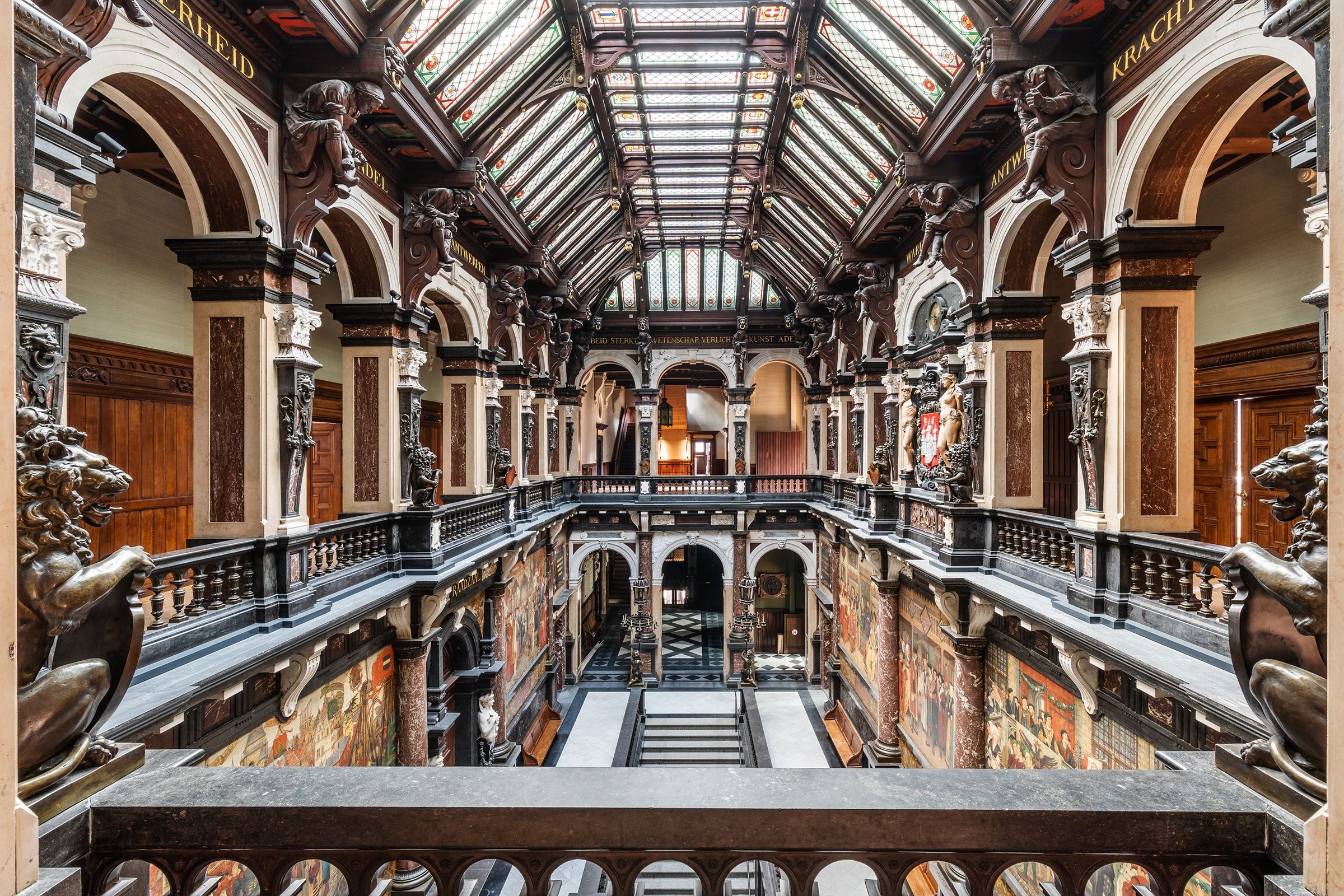 Interieur stadhuis met glazen koepel en marmeren borstwering in verschillende kleuren
