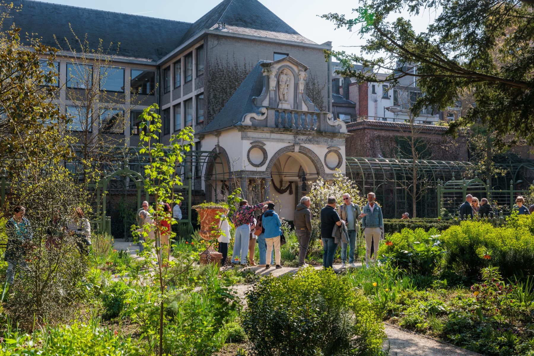 Een groepje van 7 mensen krijgt een rondleiding in de Rubenstuin