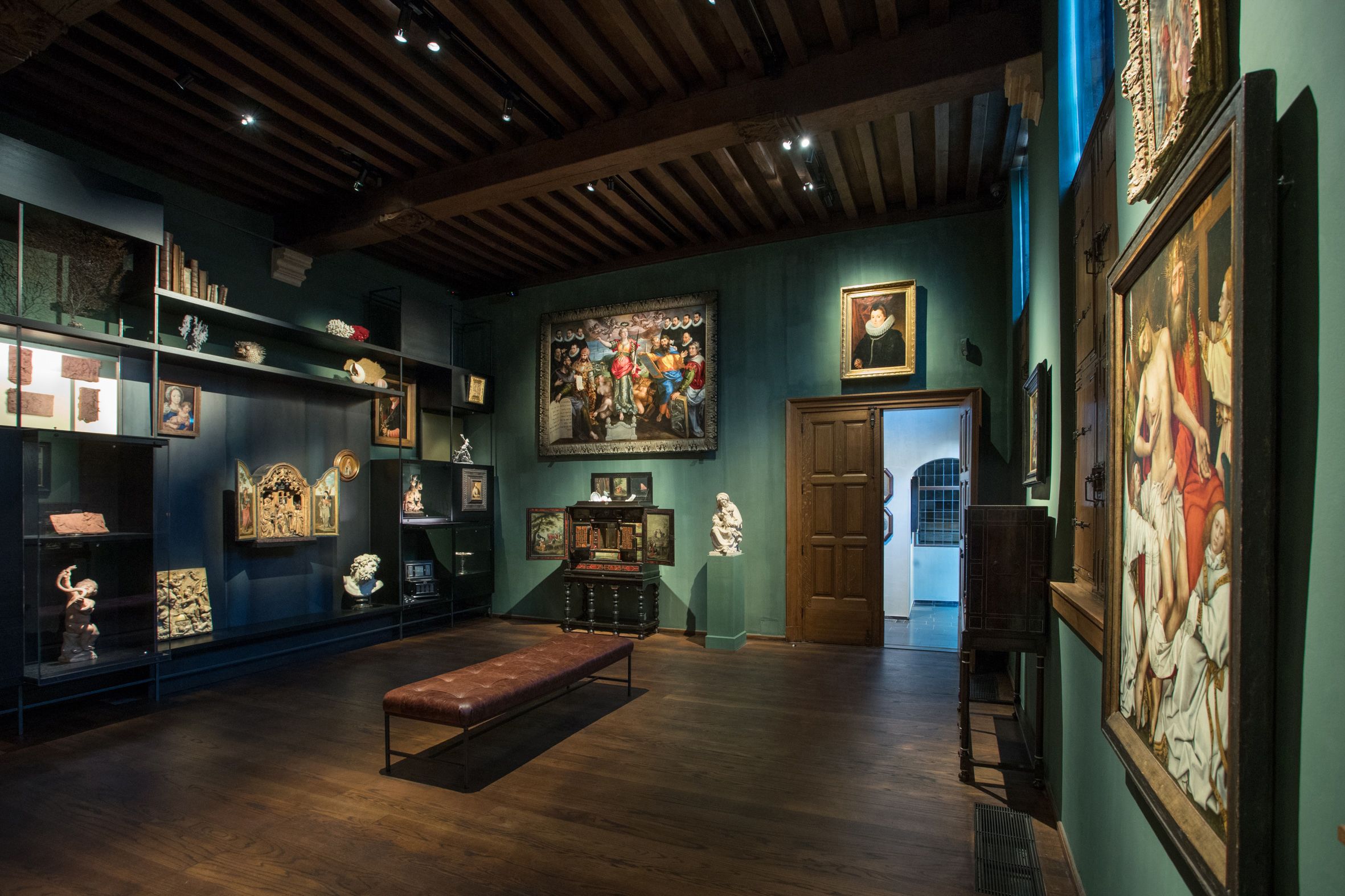 Tentoonstelling in Snijders&Rockoxmuseum. Een donker verlichte ruimte met schilderijen aan de muur.