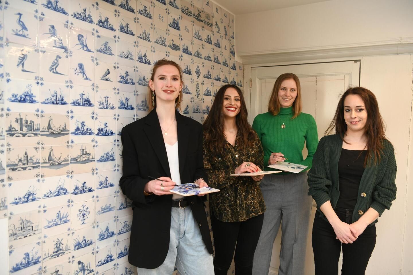 Vier studenten poseren in de tegelkamer.