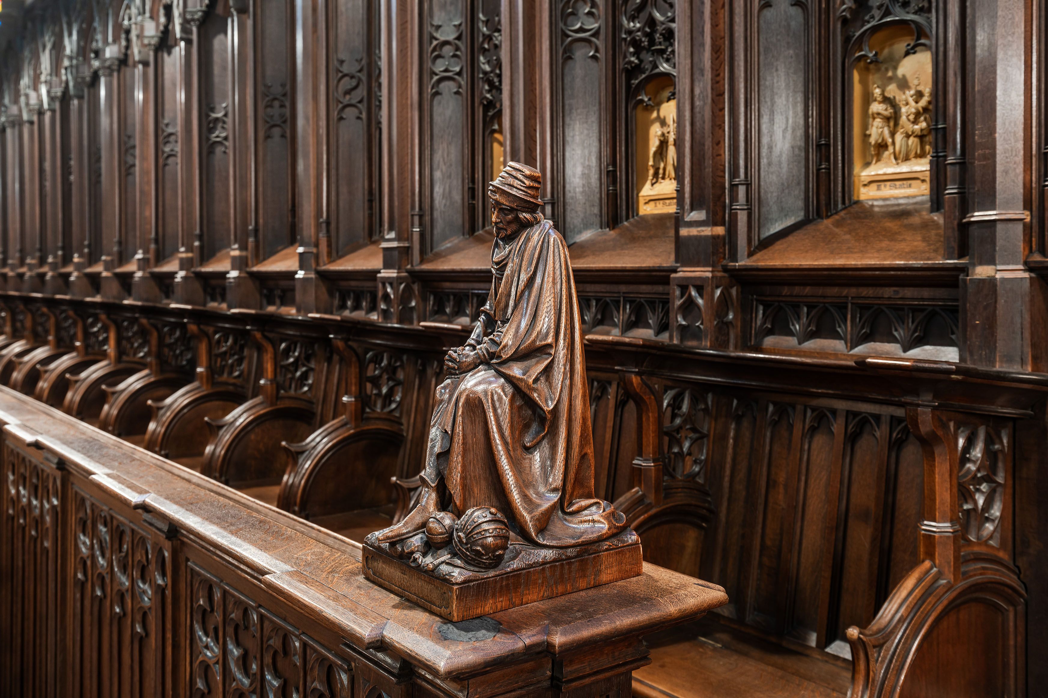 Houten bank langs de zijkant van de kapel met religies houten figuur op de hoek