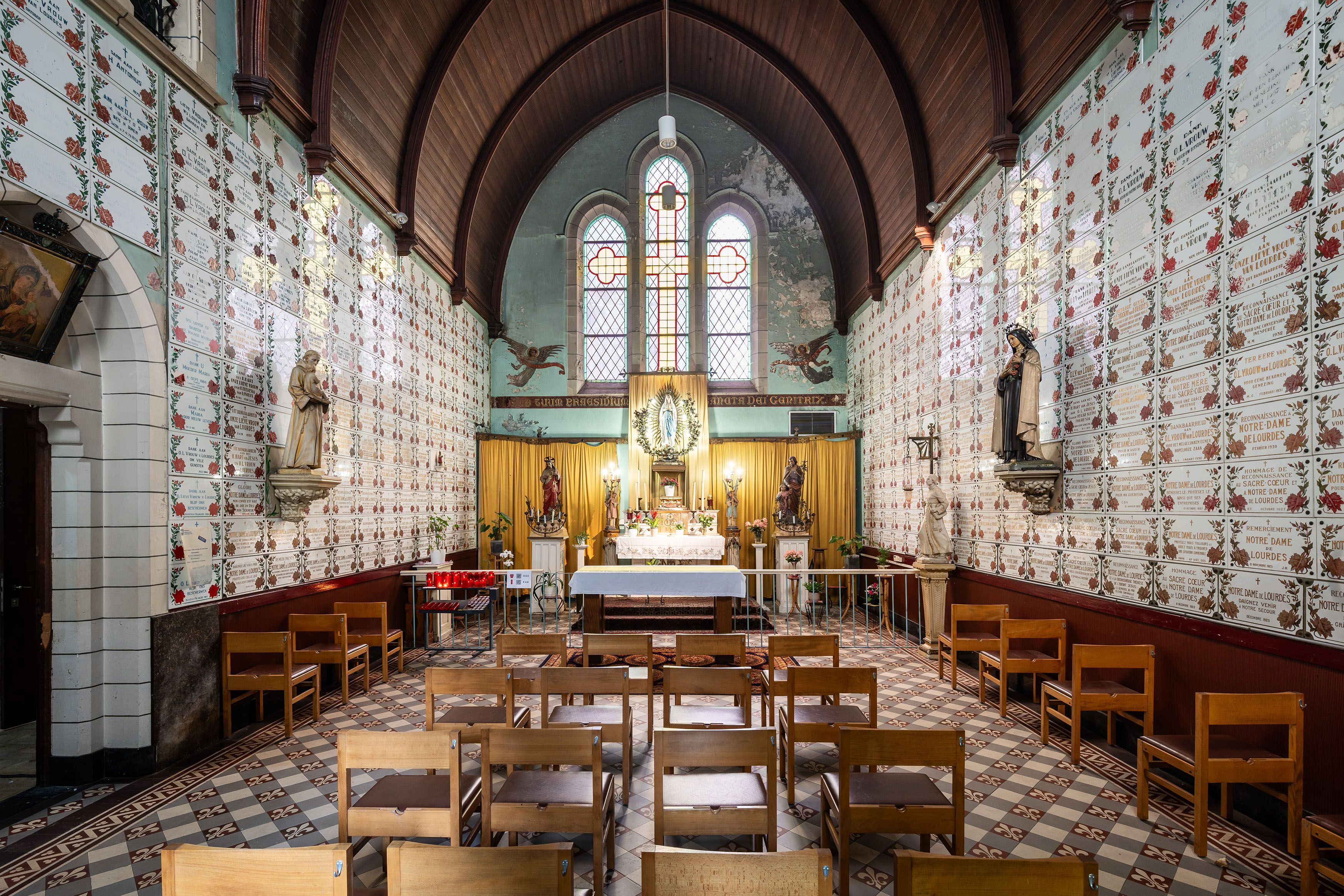 Interieur van de Heilige Familiekerk met tegels op de muren en een goudkleurig altaar.
