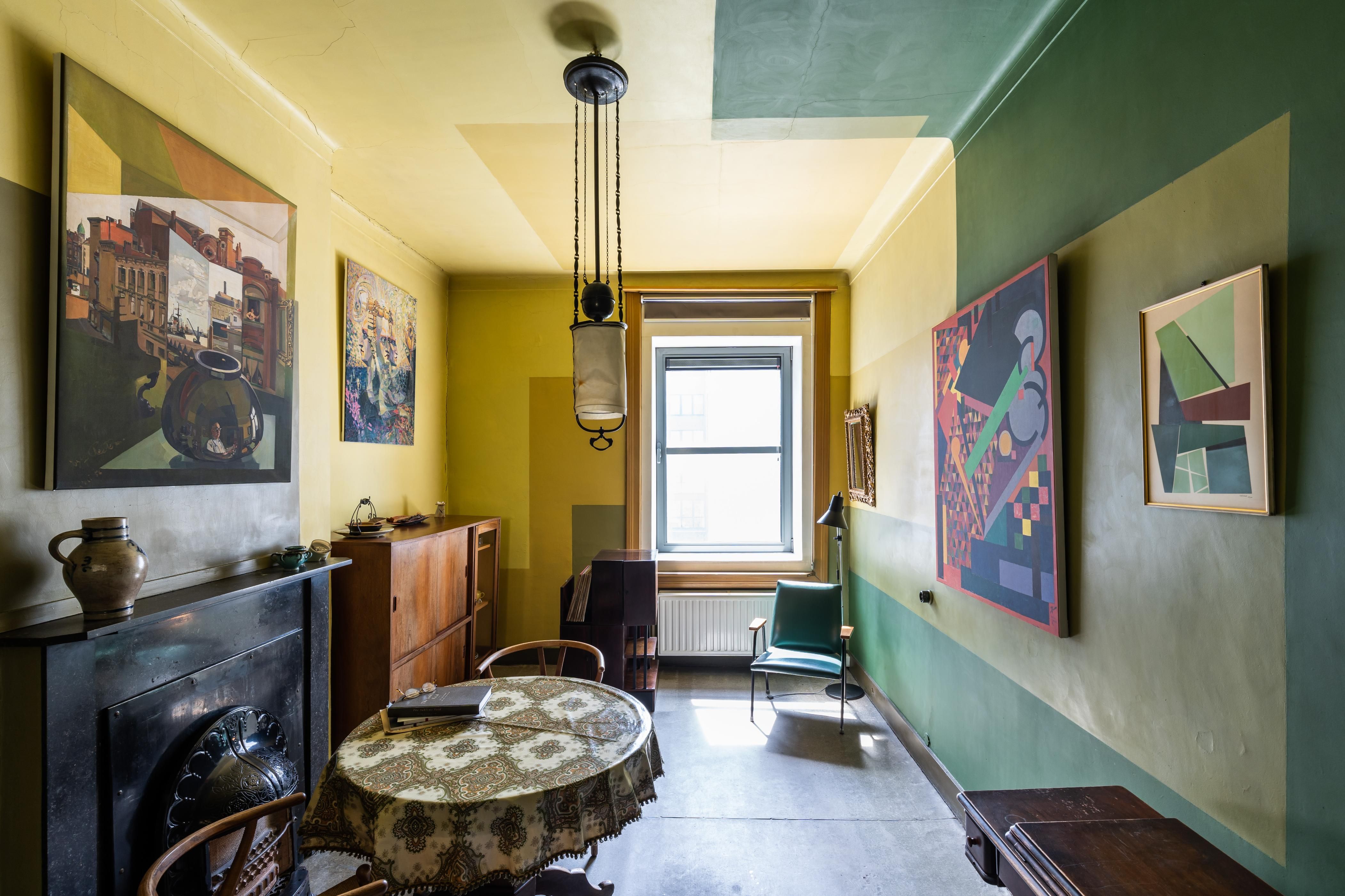Woonkamer met gele en groene muren en plafonds.