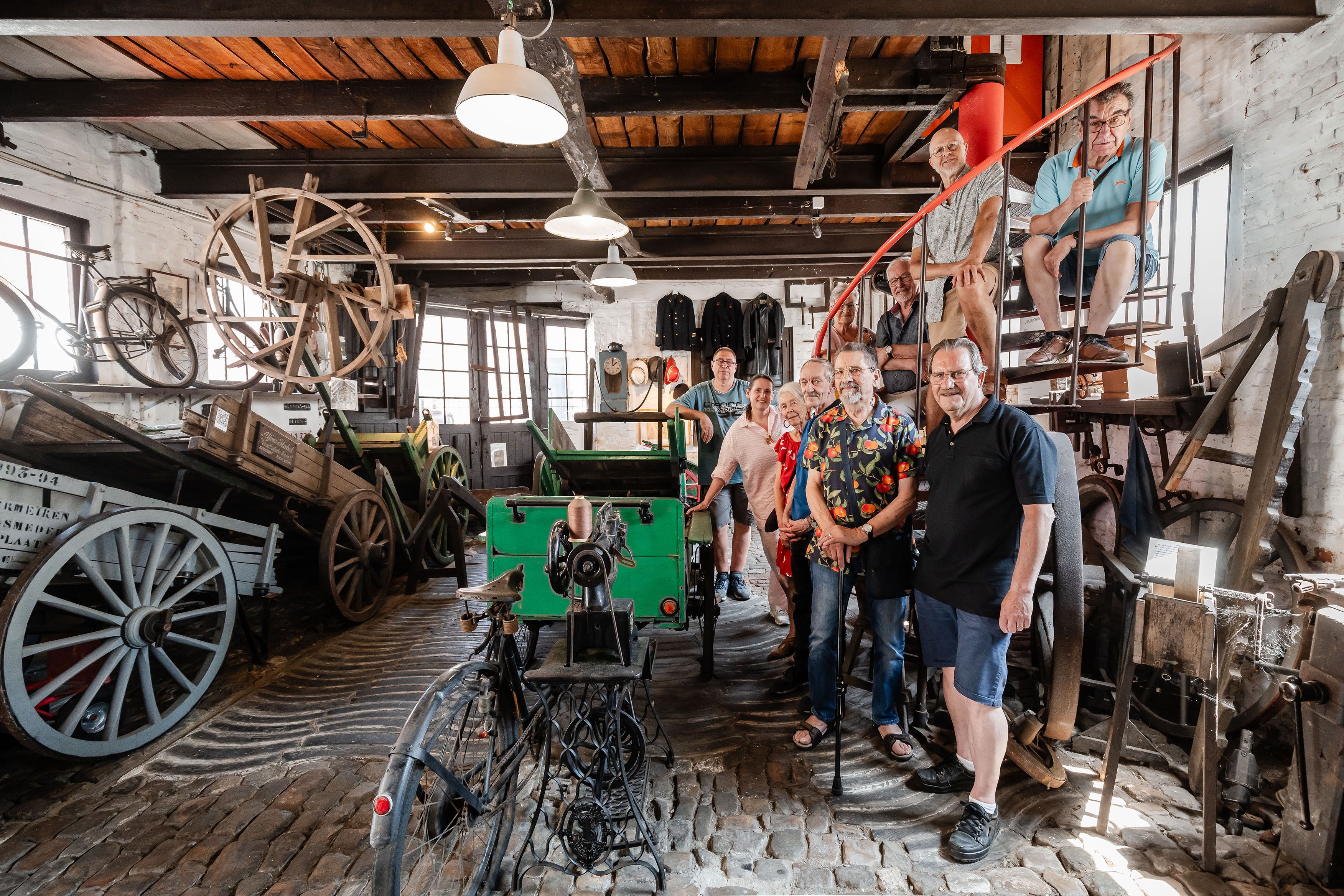 Vrijwilligers bij museumstukken van het Volxmuseum: karren.