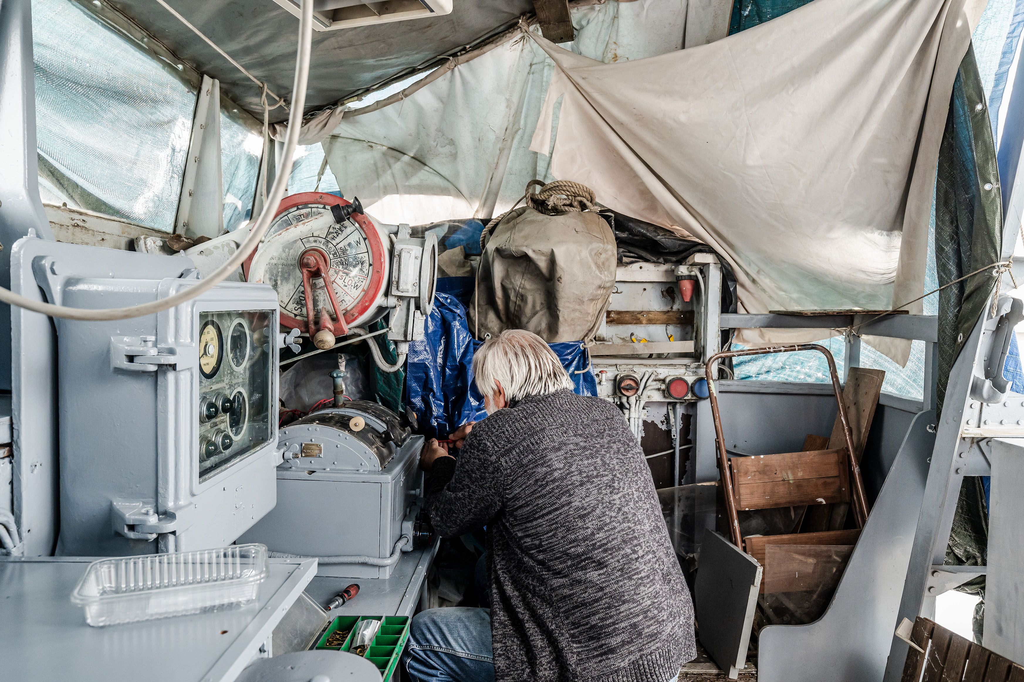 Man werkt aan de motor van het schip