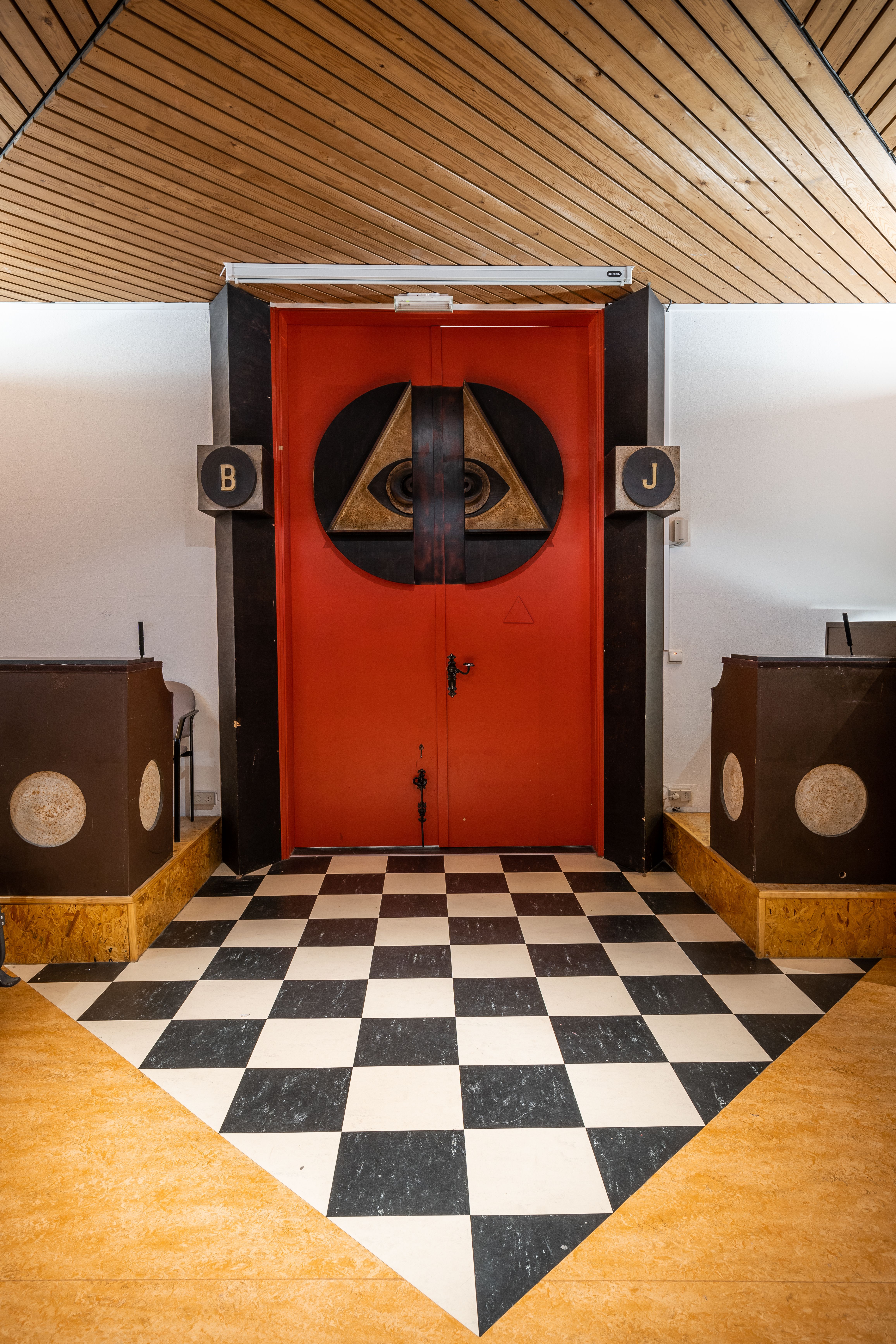 Een rode deur met symbolen die toegang geeft tot de tempel