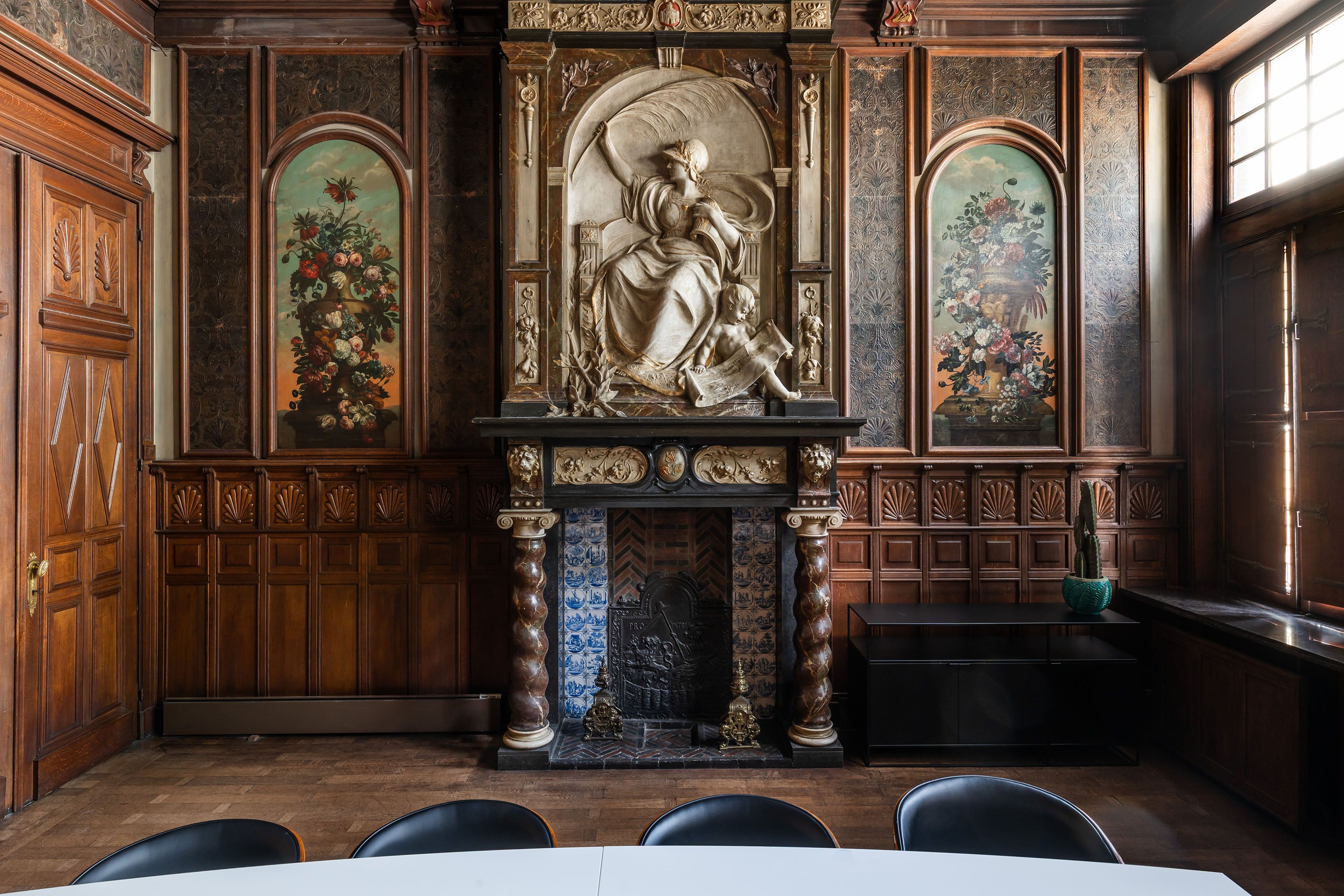 Gedetailleerd houten interieur met een open haard en een reliëf erboven.