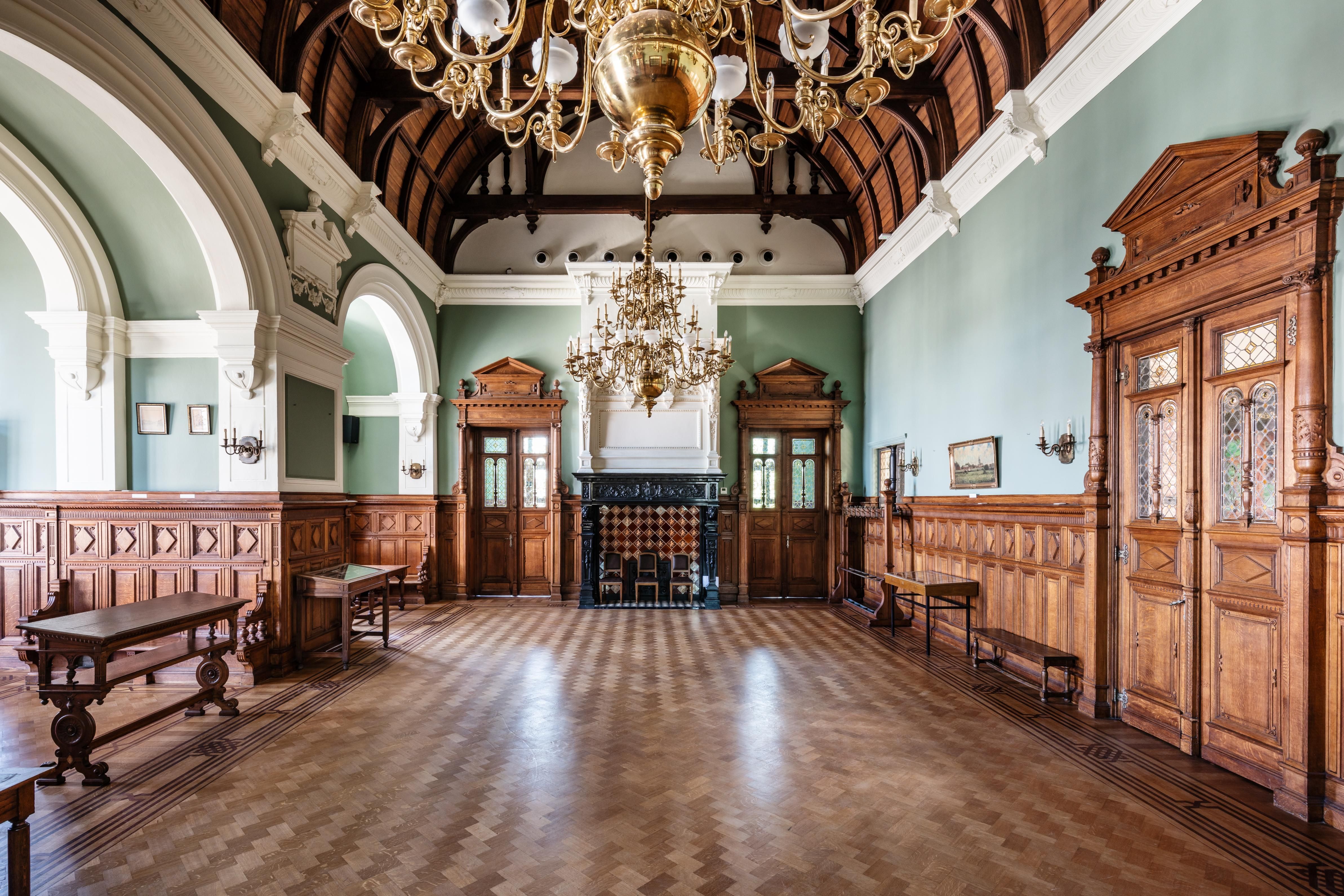 Monumentale zaal in Vlaamse neorenaissance met houten lambriseringen en een parketvloer