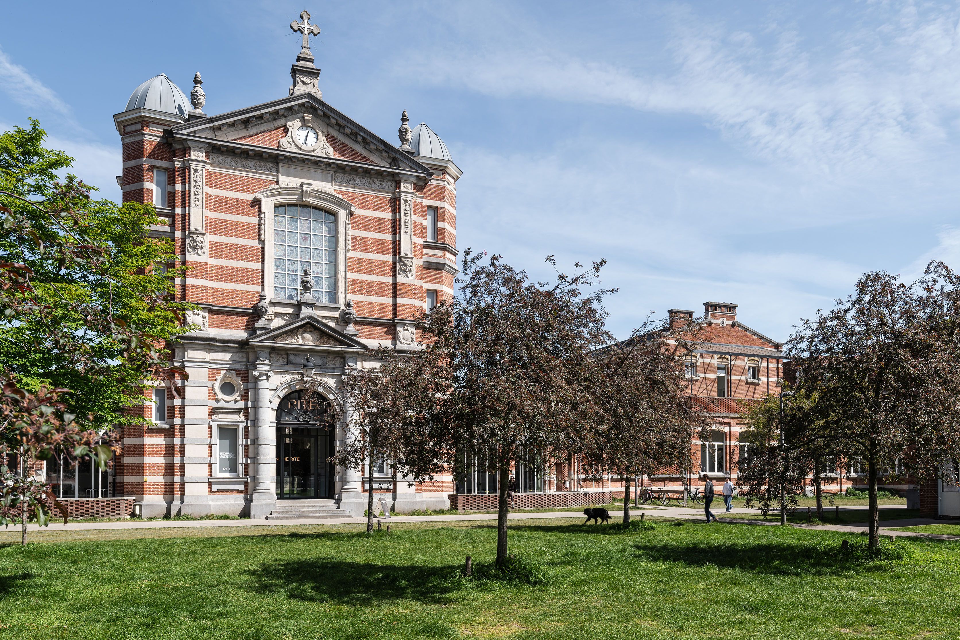 De voorgevel van de voormalige kapel van het militair hospitaal. De kapel is centraal gelegen tussen de ziekenhuispaviljoenen en is met de overige bouwdelen verbonden door middel van een overdekte gang. Het bakstenen gebouw is eclectisch opgevat met een overwegend neoclassicistisch gevelschema met neo-Vlaamserenaissance- en neobarokke elementen