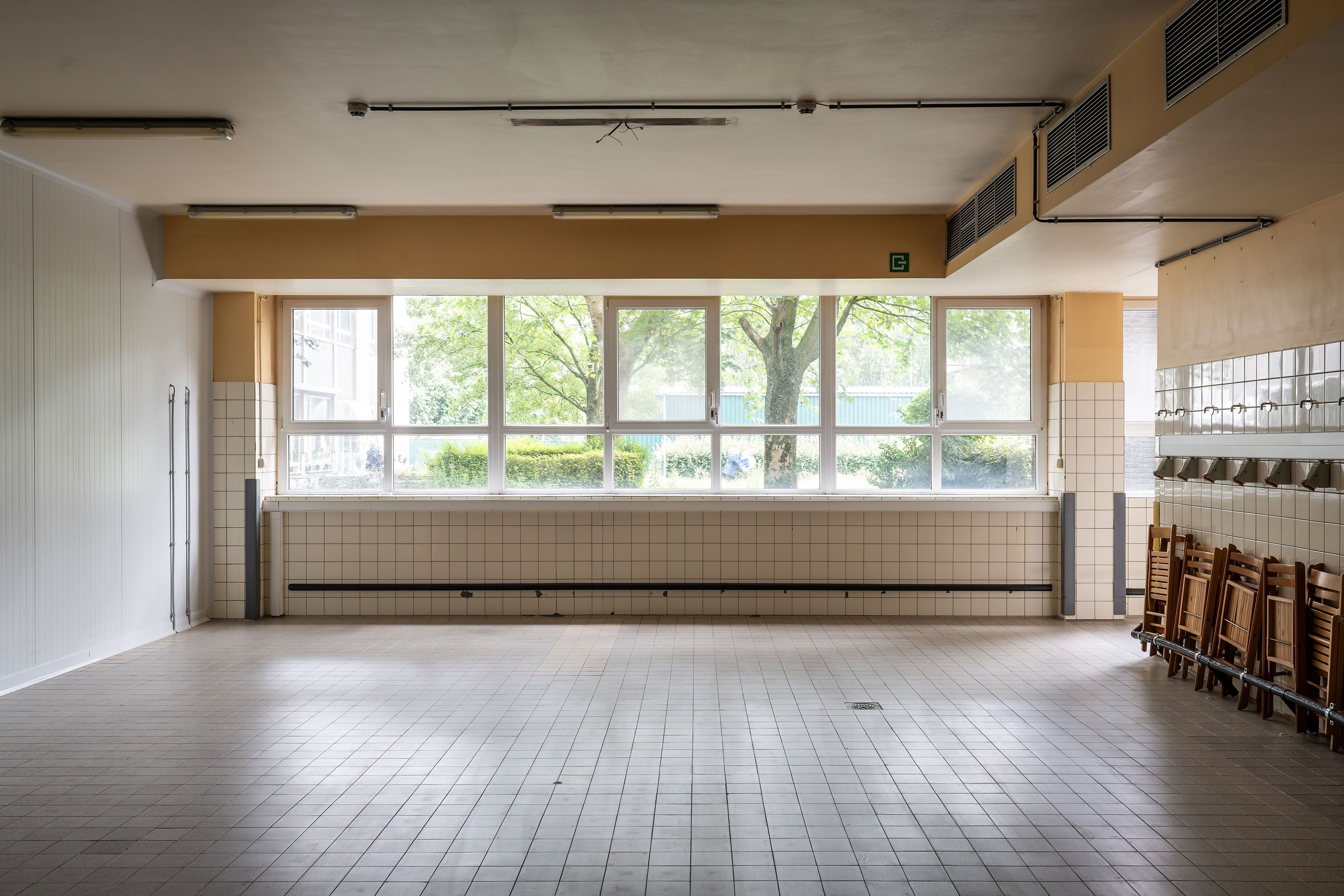 Lege ziekenhuisruimte met lichtgekleurde vierkante vloertegels.