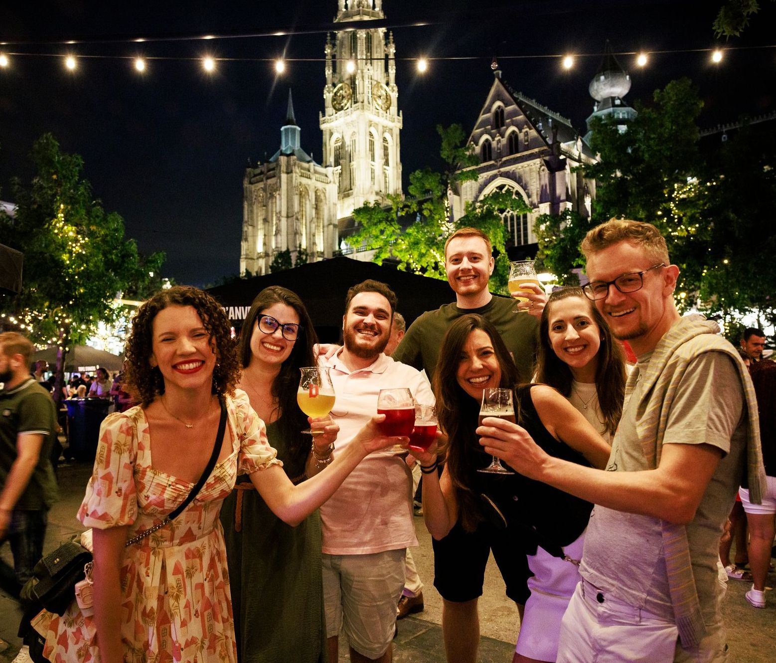 Groep vrienden met verschillende drankjes op de Groenplaats 's avonds tijdens het Bollekesfeest