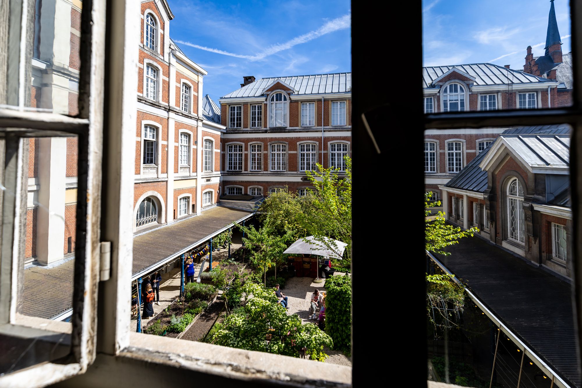 Zicht op het gebouw en de binnentuin vanuit een raam.