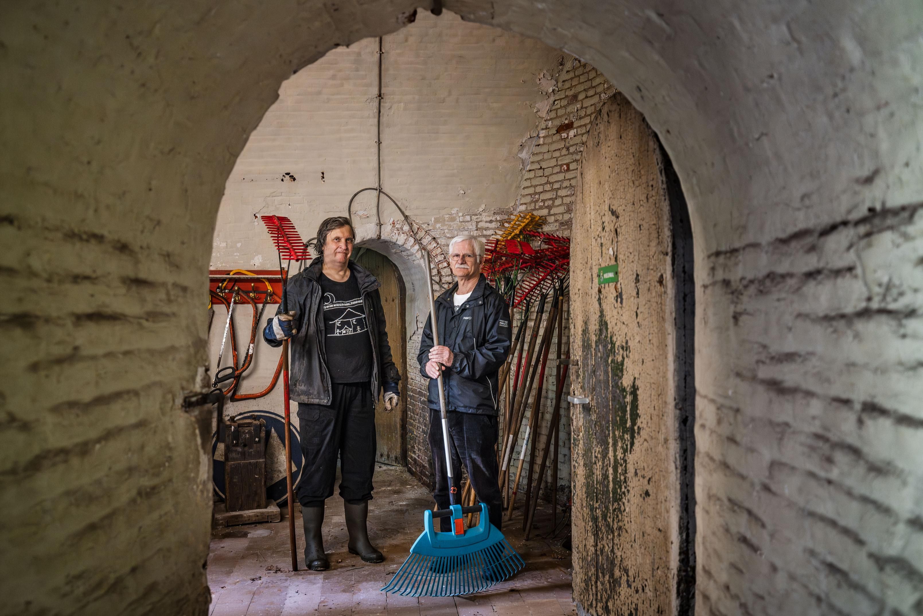 Vrijwilligers poseren met hun werkgerief in het fort.