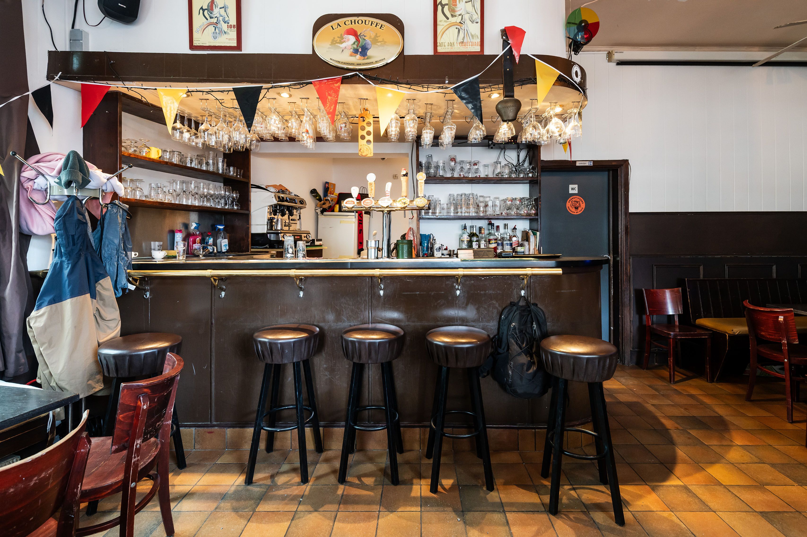 Interieur van café Het Chauffeurke met zwarte toog en 5 zwarte krukken.