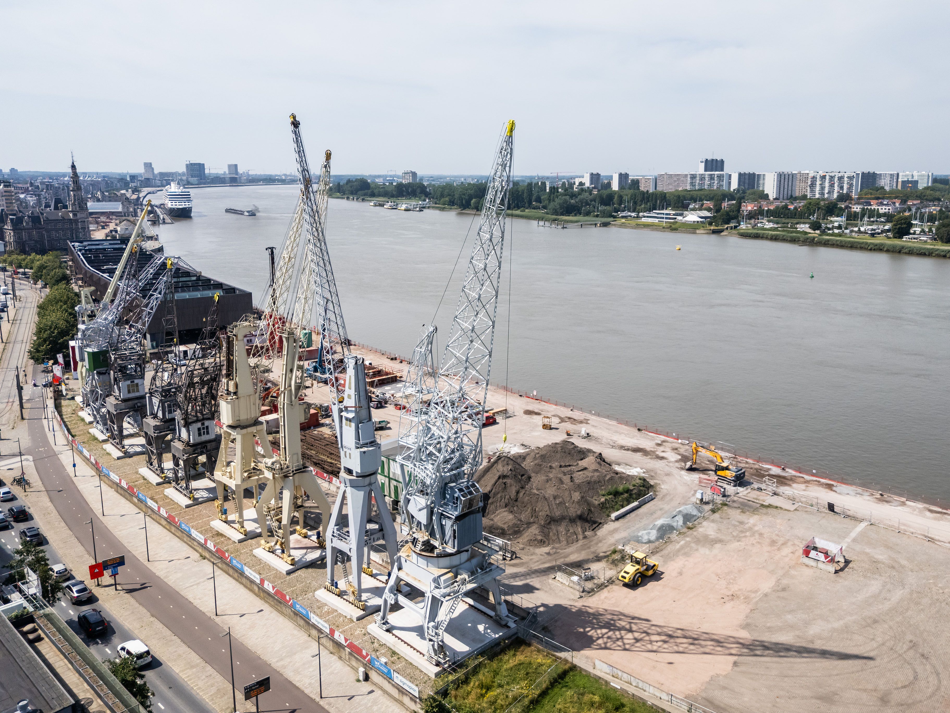 Luchtfoto van negen havenkranen, opgesteld langs de Scheldekaaien.
