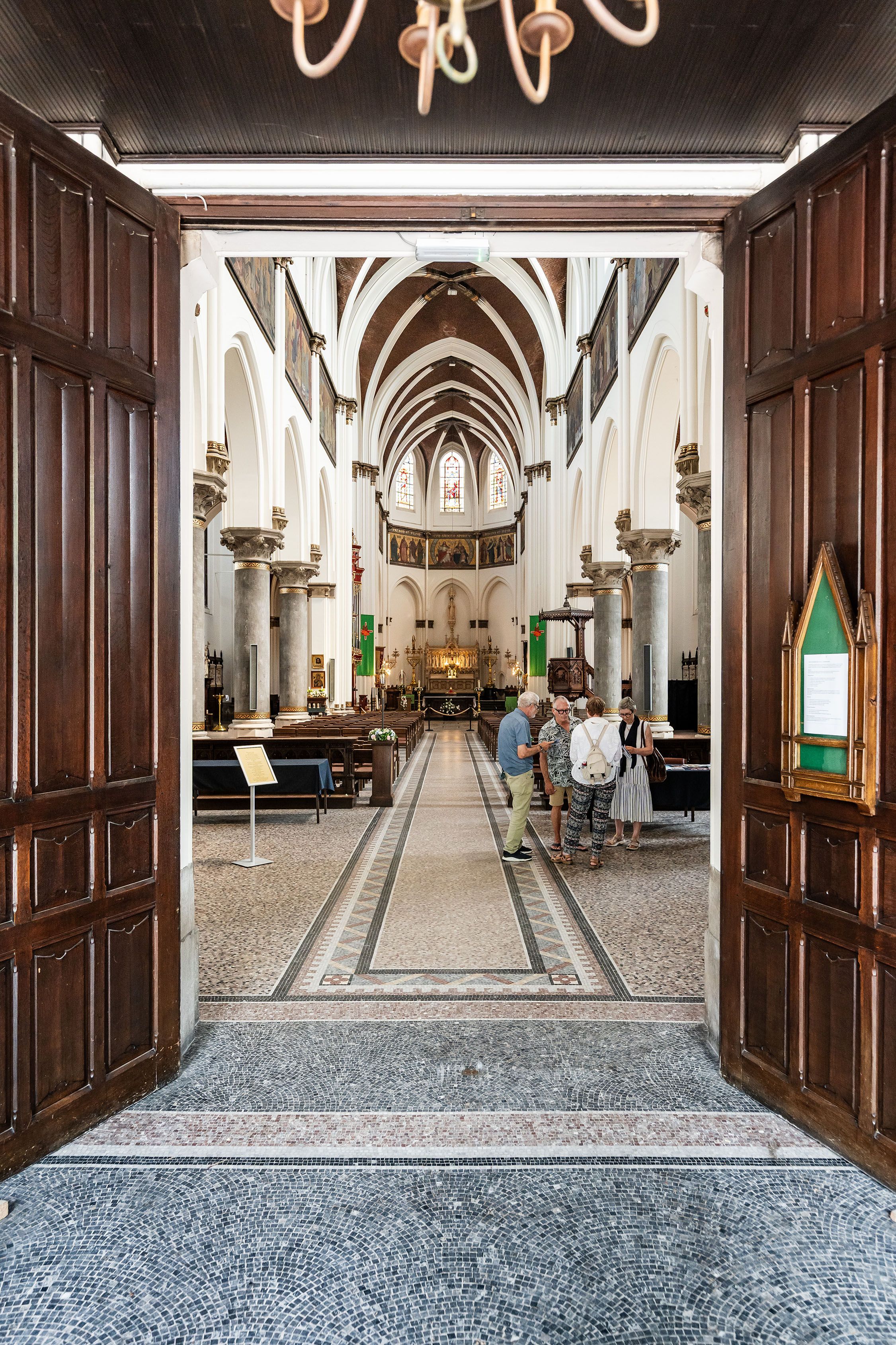 Je kijkt door de inkomdeur binnen in de Sint-Norbertuskerk