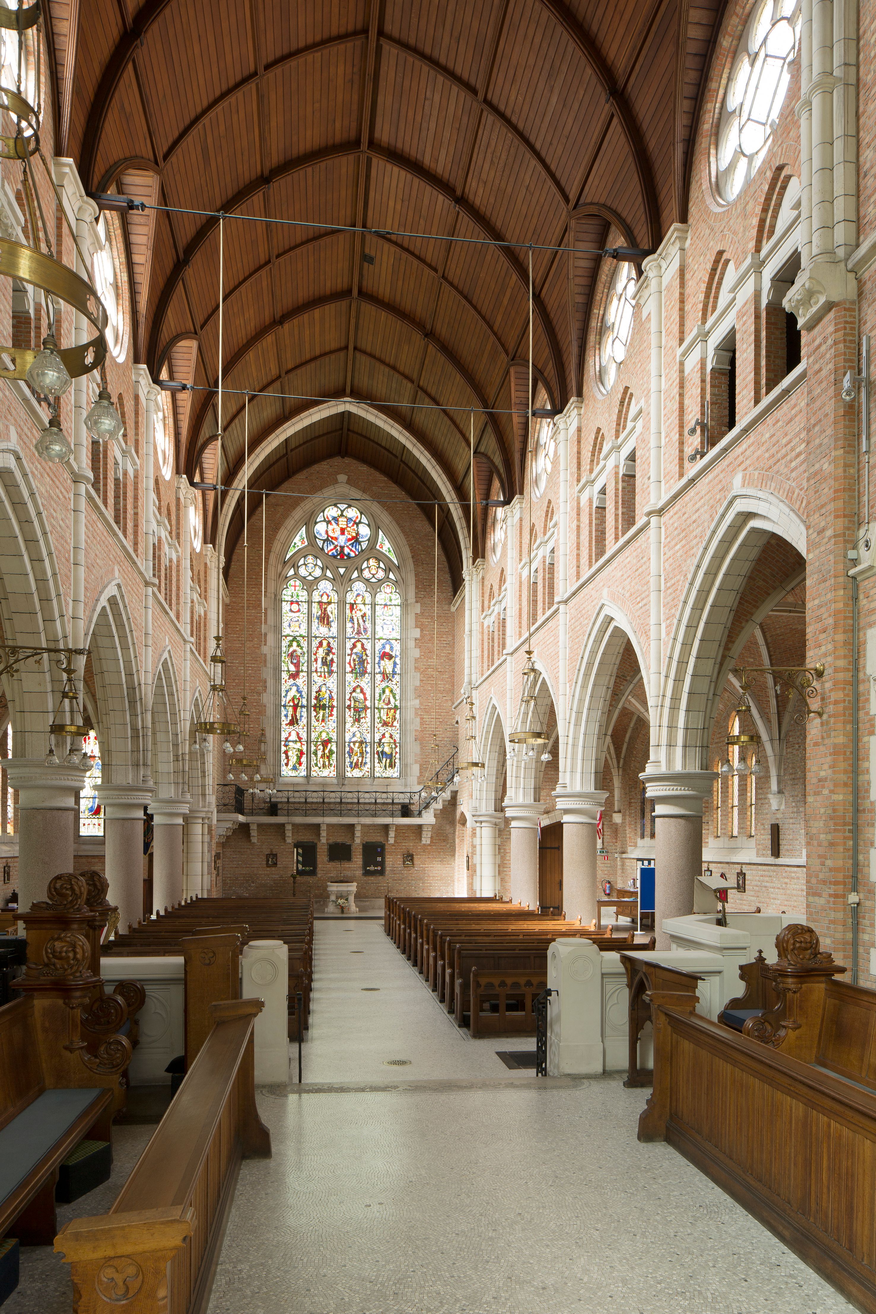 Interieur van de Sint-Bonifaciuskerk met houten plafond, muren in rode baksteen opgevoegd met een lichte mortel.