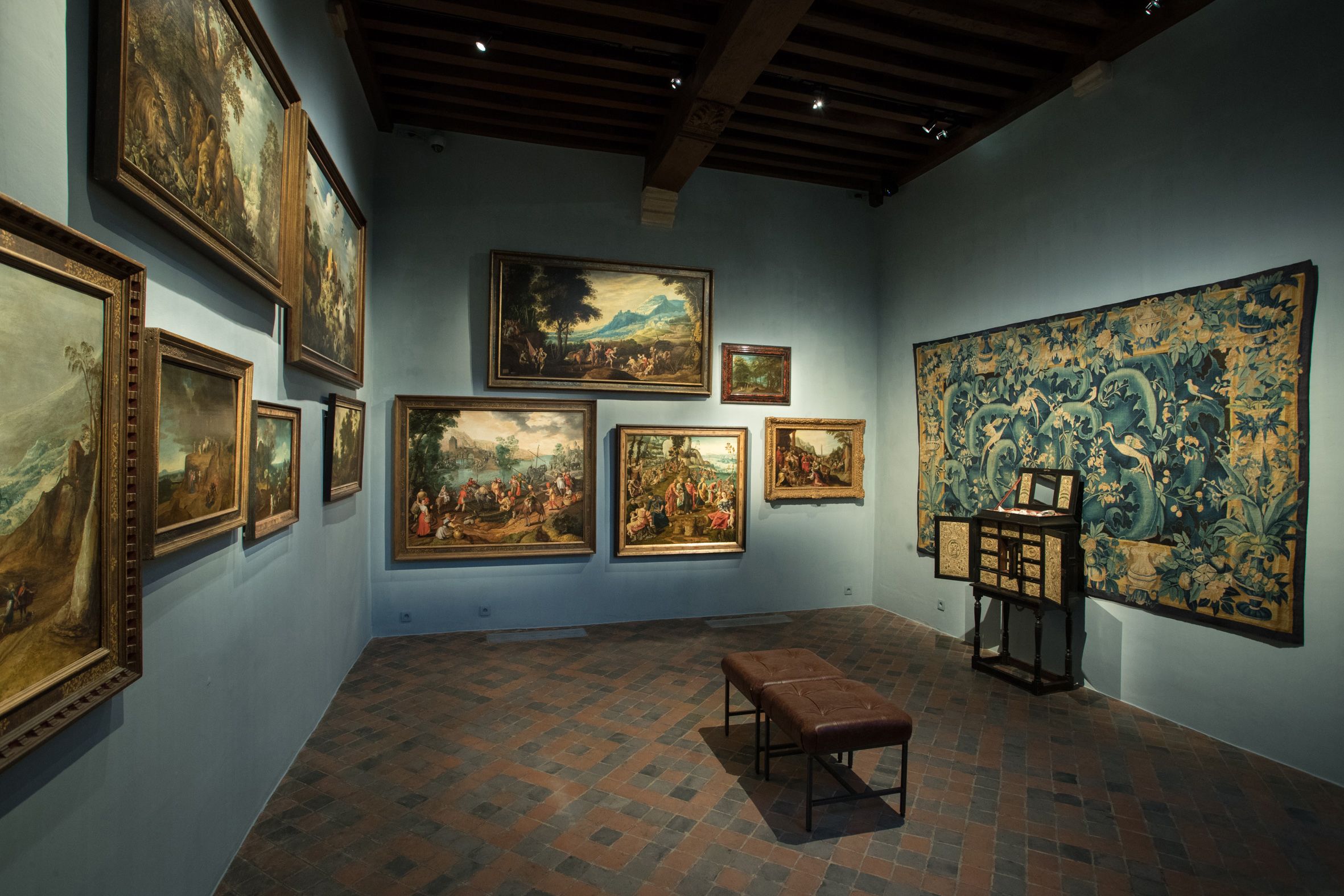 Tentoonstelling in Snijders&Rockoxmuseum. Een donker verlichte ruimte met schilderijen aan de muur.