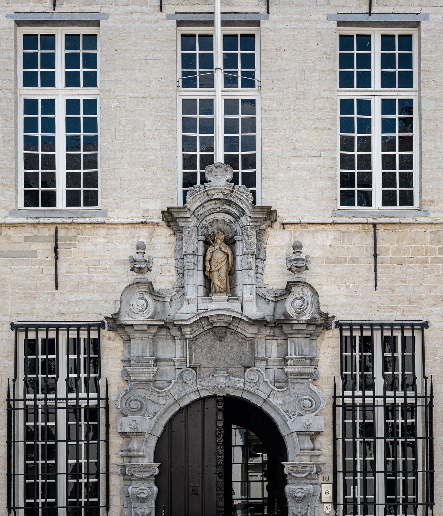 De gevel van het museum met versierde ingang en houten poort.