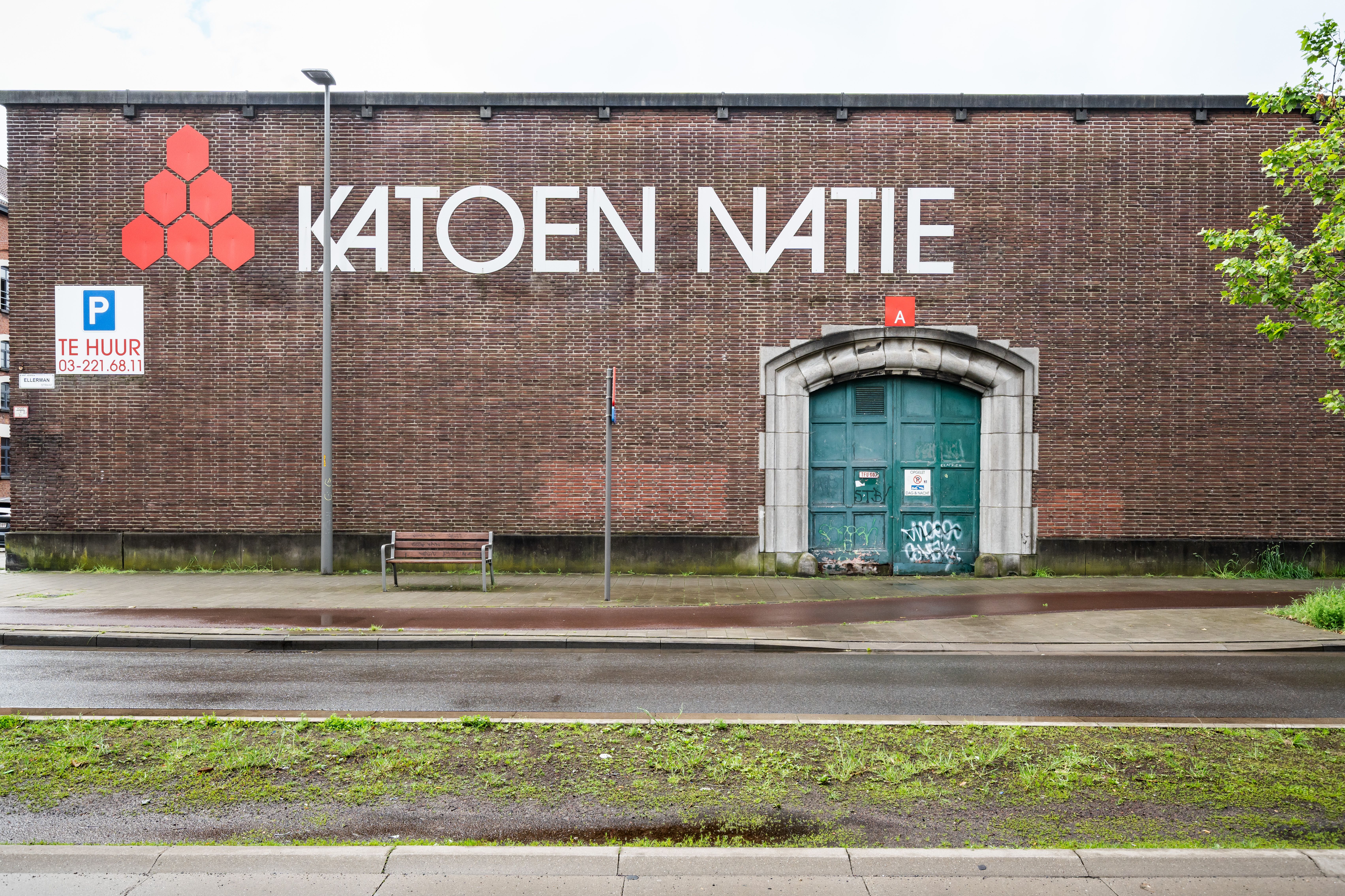 Exterieur van het voormalige pakhuis Den Argentin. Tegen de bakstenen muur is het logo van de huidige eigenaar, Katoennatie, aangebracht.