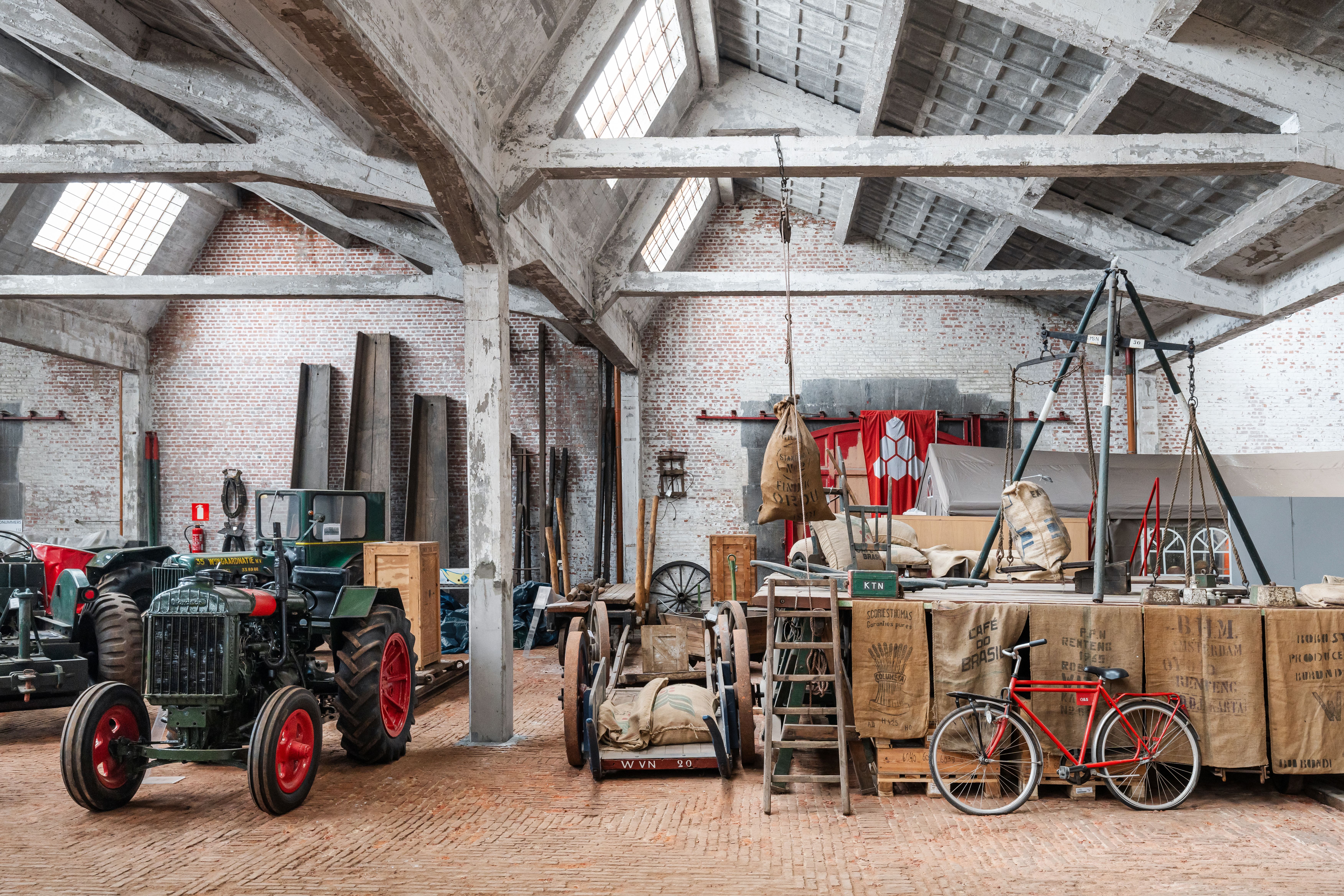 Interieur van het voormalig pakhuis met zijn betonnen draagstructuur en zicht op de collectie die in het pakhuis wordt bewaard..
