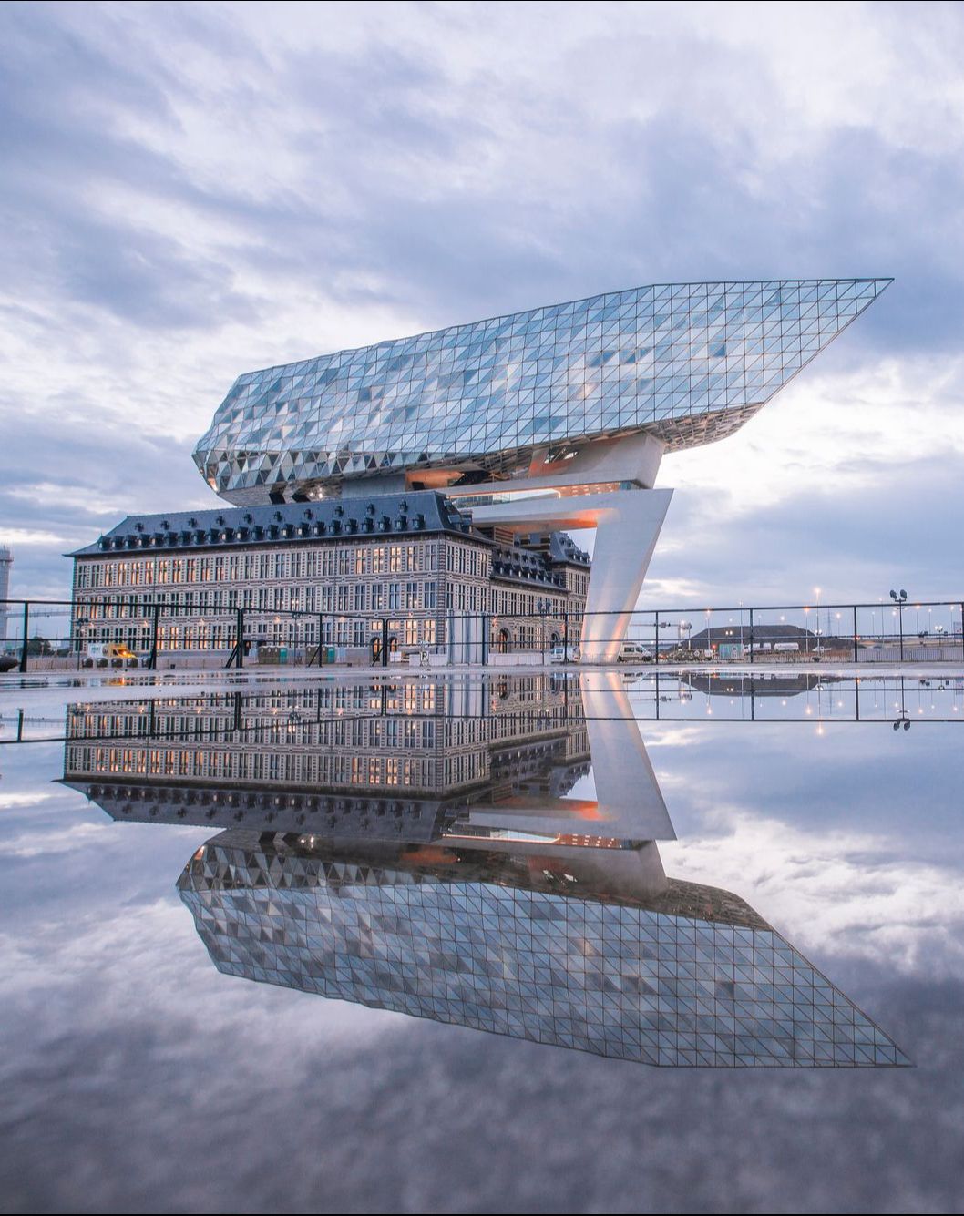 Het Havenhuis met zijn reflectie op de natte stenen van het plein ervoor.