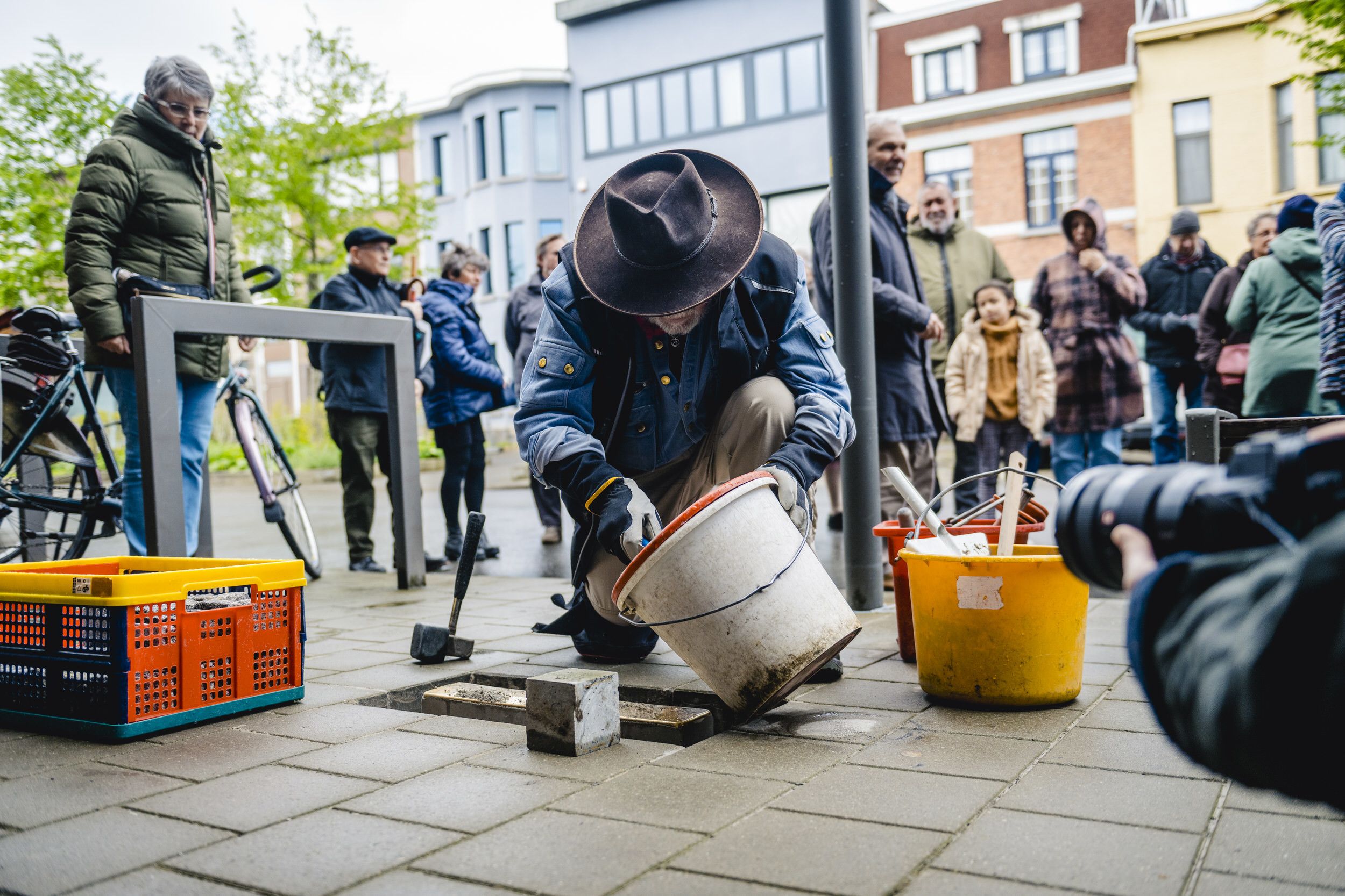 Vrijwilligers plaatsen struikelstenen in het voetpad.