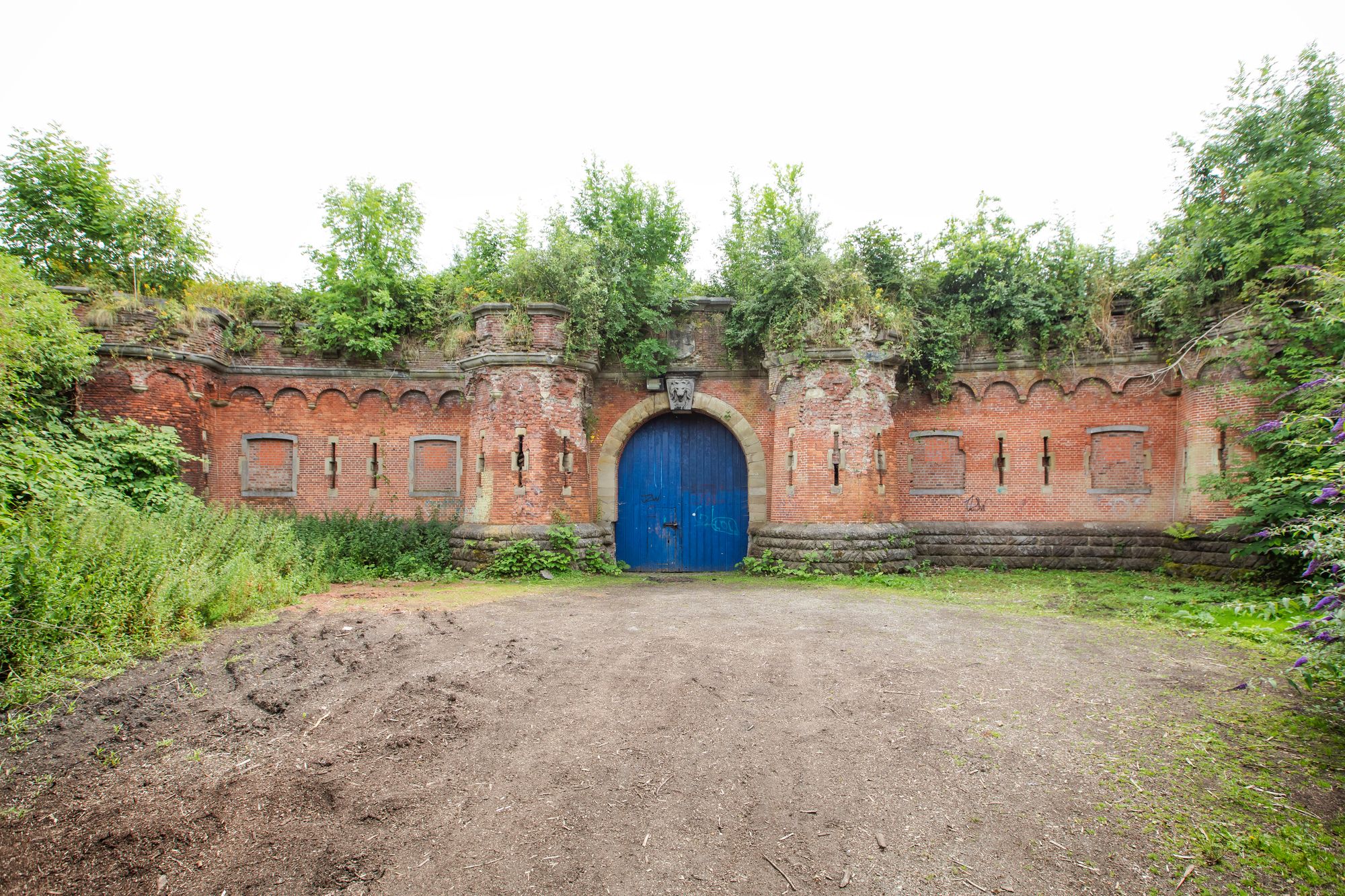 Zicht op op ingang fort 3 Borsbeek met blauwe rond poort