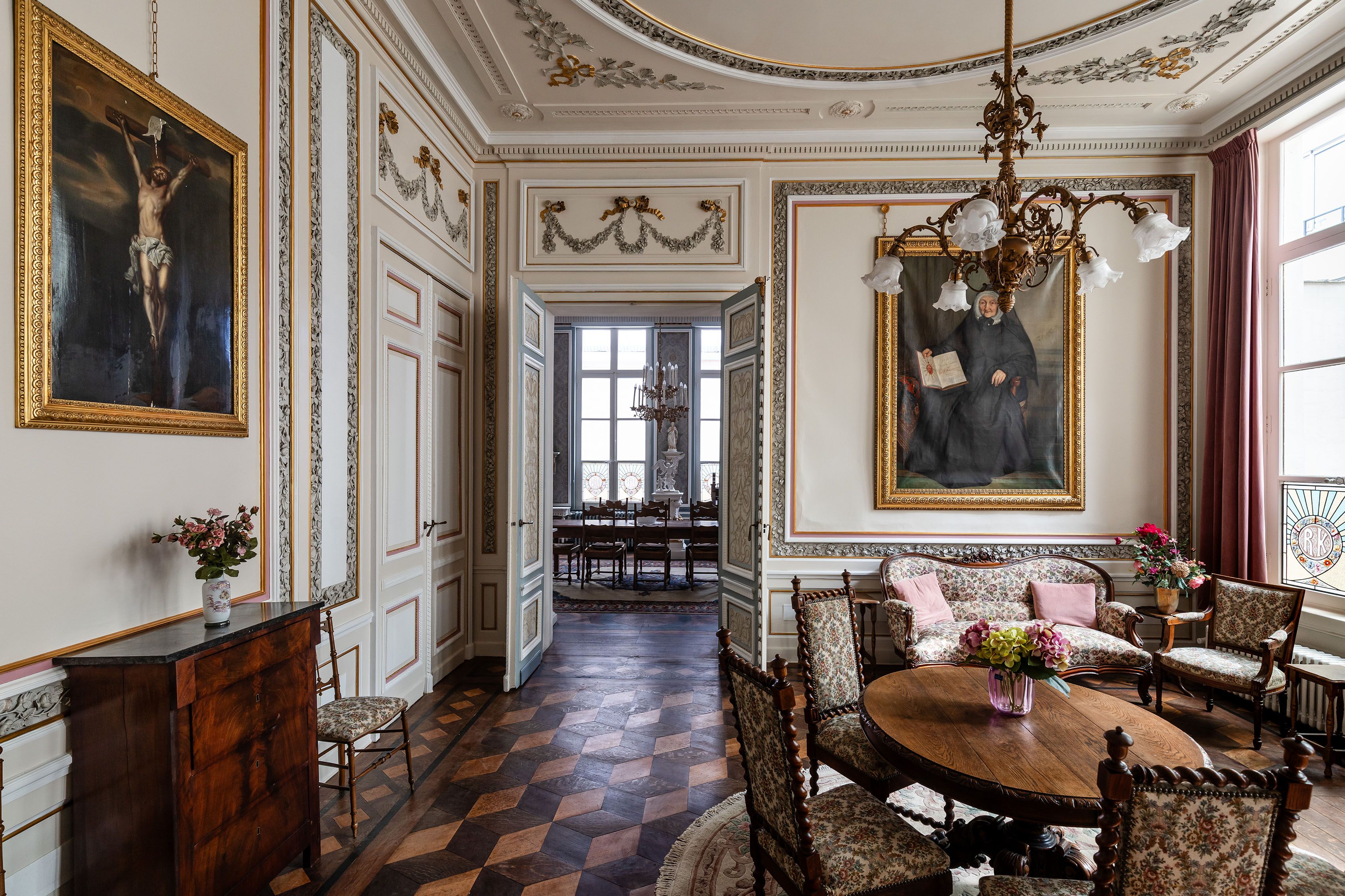 Beeld van salon in laat-rococostijl met eettafel, 4 stoelen en schilderijen aan de wand.