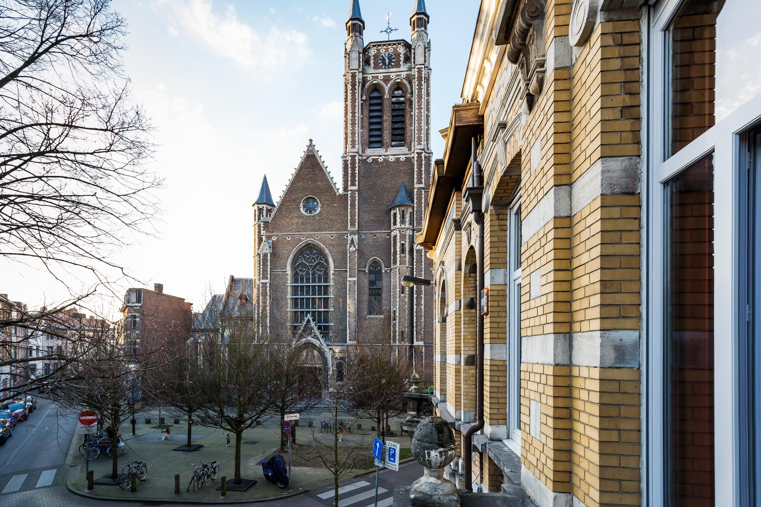 Zicht op de Sint-Hubertuskerk en gevels met gele baksteen