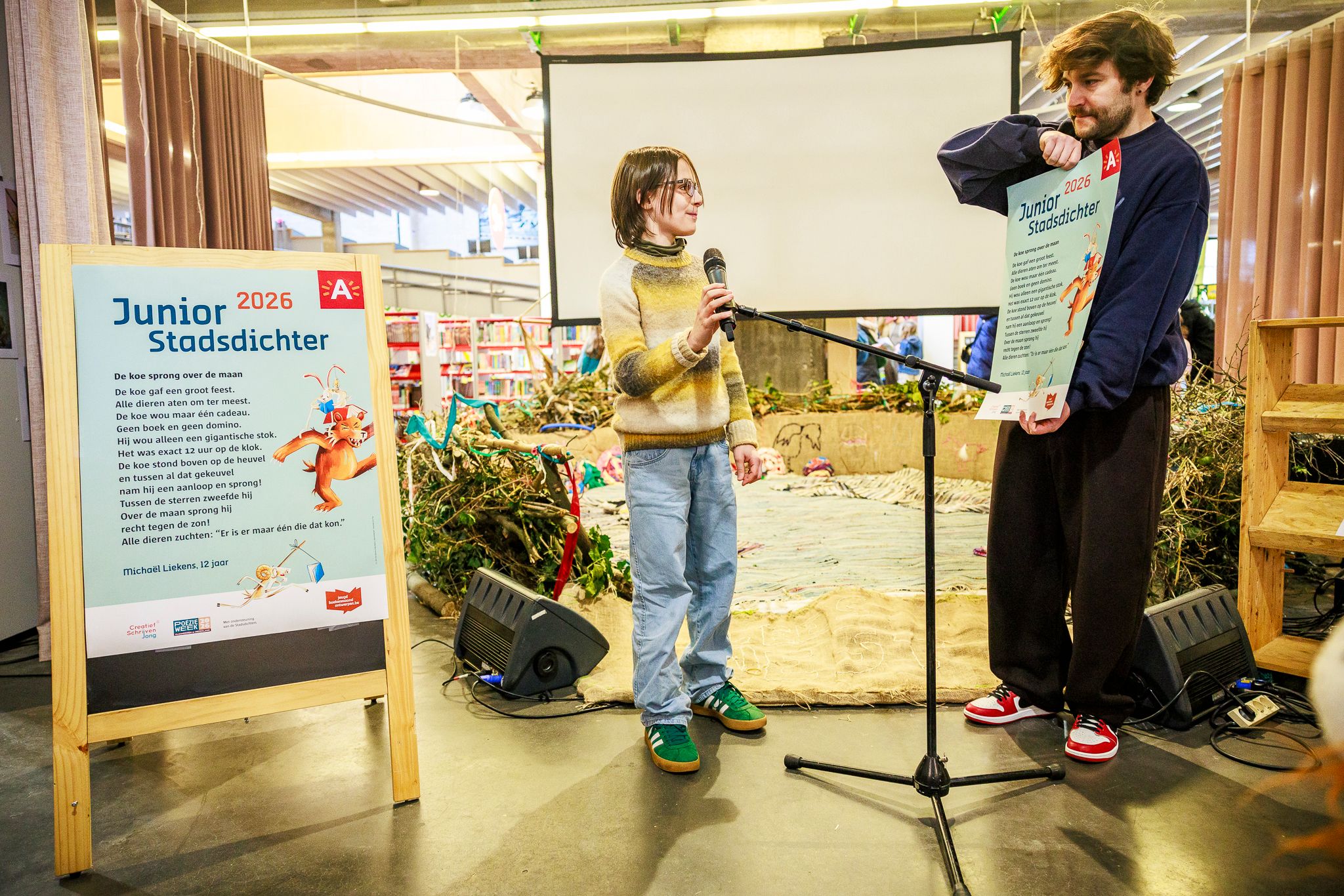 Dempsey Hendrickx overhandigt de kersverse Junior stadsdichter een affiche met zijn winnende gedicht erop